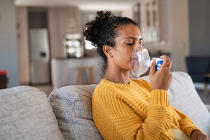 A woman using a nebulizer.