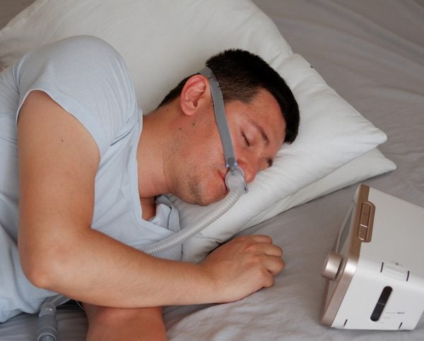 Sleep Center - Jamaica Hospital Person lying on a bed using a portable sleep apnea monitoring device during a home sleep study.